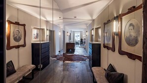 A hallway with wooden flooring, benches, and framed portraits on the walls. - Modern flat in the centre of Hopfgarten with 2 bedrooms (Hopfgarten)