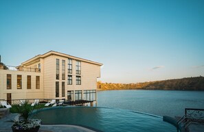 Un hotel moderno con piscina y vistas a un lago.