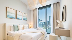 Een moderne hotelkamer met een groot bed, een bureau en uitzicht op de stad.