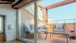 A modern living room with a glass door leading to an outdoor patio area. - Authentic Architectural Gem in the Heart of Rome
 (Roma)