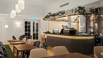 A restaurant with a bar area, wooden tables, and chairs.