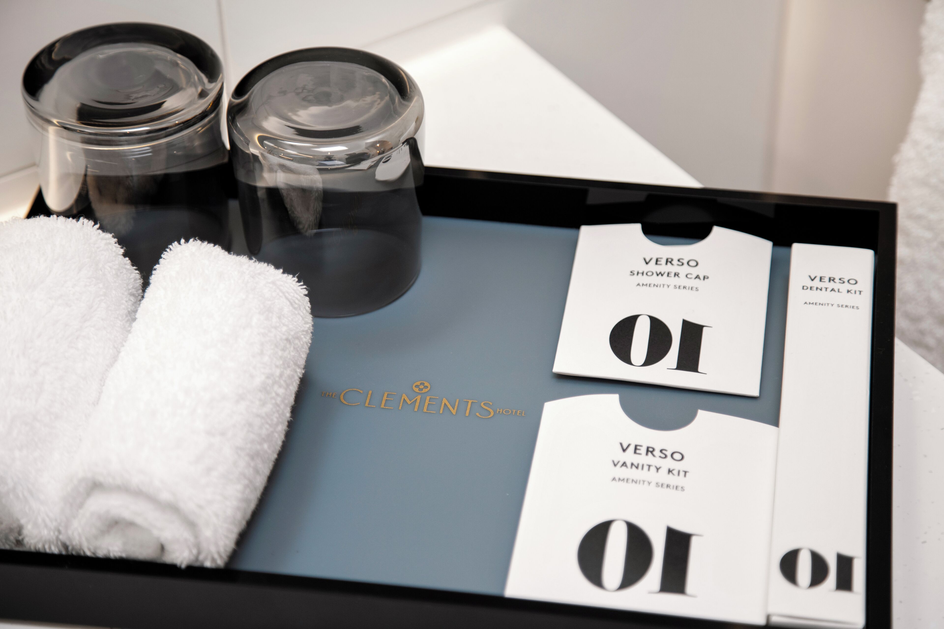 A tray with toiletries including a shower cap, a dental kit, and towels.