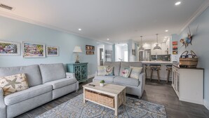 A modern living room with a grey sofa, a coffee table, and a patterned rug.