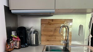 A compact kitchen with a dishwasher, a coffee maker, and a sink. - La Maison del Mar: 1º4 Deluxe Room with Terrace/Bathroom near the Beach (Málaga)