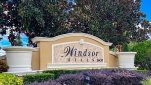 Schild für Windsor Hills, mit freier Sicht auf den Eingangsbereich und die umliegende Grünanlage.