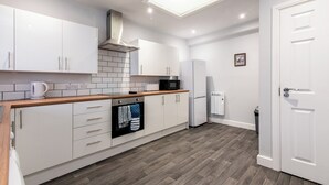 A modern kitchen with white cabinets, a black microwave, and a built-in oven.