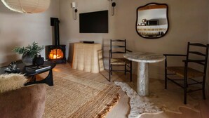 Una sala acogedora con chimenea, una mesa redonda y sillas.