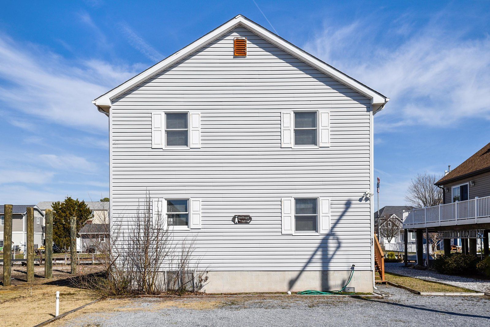 A two-story building with a gabled roof and white siding.
