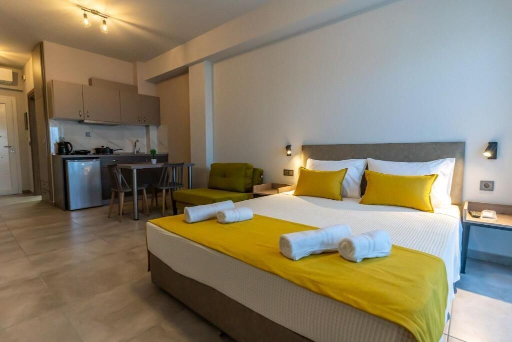 Una camera d'albergo con un letto, un angolo cottura, una zona pranzo e un bagno.