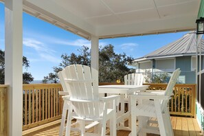 Relax on the deck with a view of the surrounding trees and building.