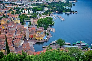 A waterfront cityscape with historic buildings, a marina, and a river. - Appartamento Centro Storico Riva 2 (Riva del Garda)