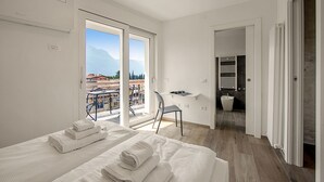 Ein modernes Hotelzimmer mit einem großen Bett, einem Schreibtisch und Blick ins Freie.