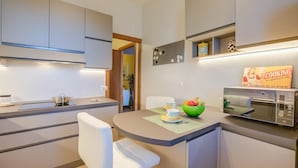 A modern kitchen with a built-in microwave, a small island with seating, and a sign indicating the kitchen is closed. - Alel Classy And Chic Apartment (Stresa)