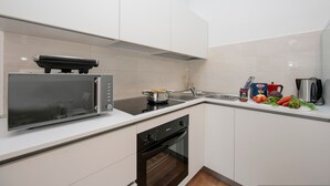 Una cocina moderna con microondas, horno y lavavajillas integrados.