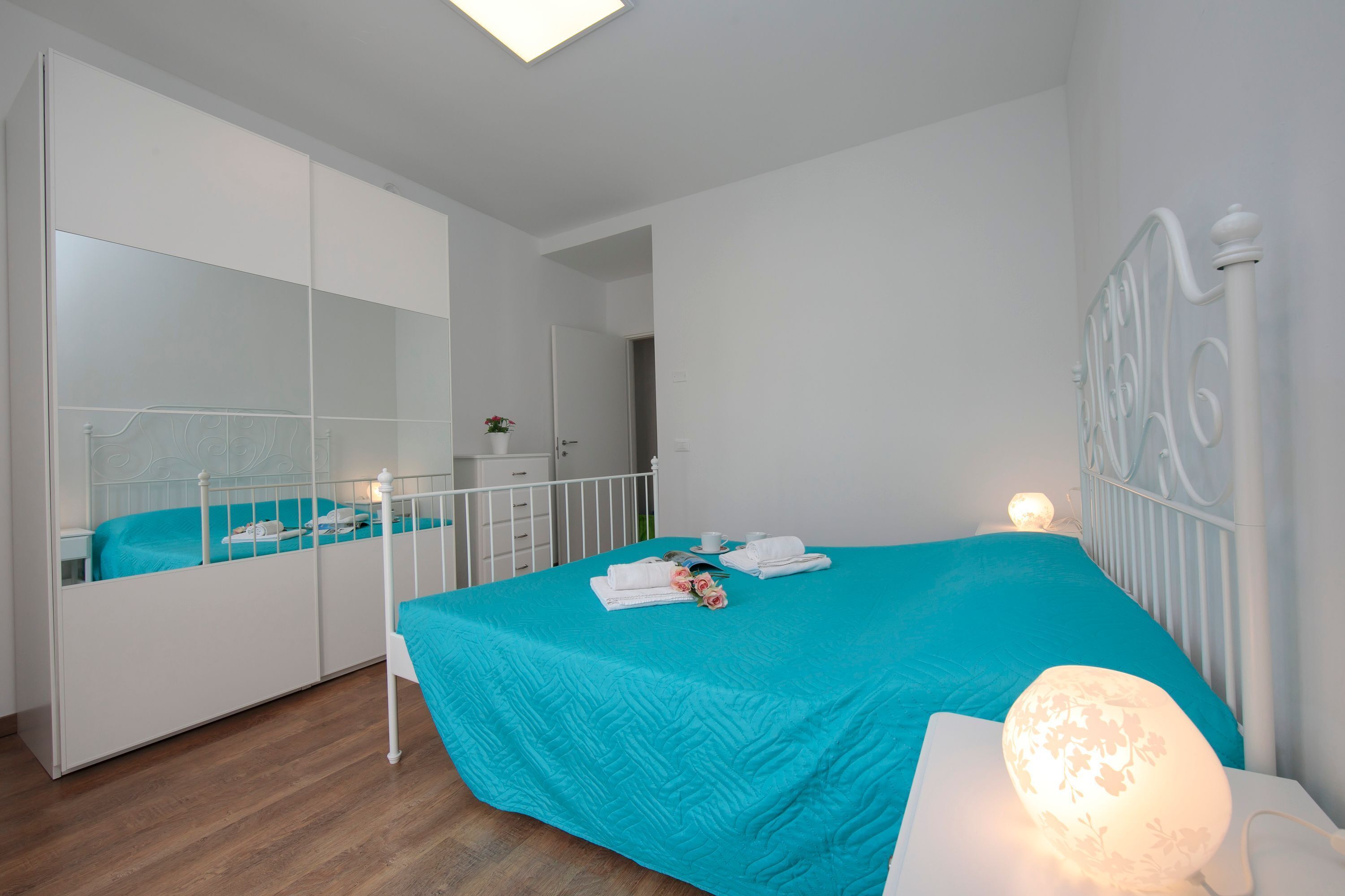 Une chambre à coucher avec un lit, une table de chevet, une lampe et une armoire.