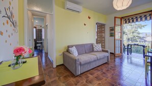 Ein Wohnzimmer mit einer Couch, einem Esstisch und einem Balkon mit Blick.