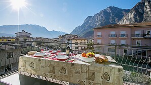 Una terraza con una mesa lista para una comida, con vistas a un paisaje montañoso.