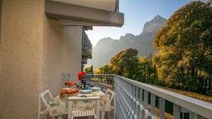 A balcony with a table set for dining, chairs, and a railing. - Riva Lago e Spiaggia Apartment 3 (Riva del Garda)