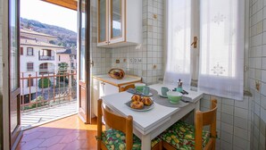 A dining area with a table, chairs, and a view of a balcony. - Easy Central Stresa in Stresa (Stresa)