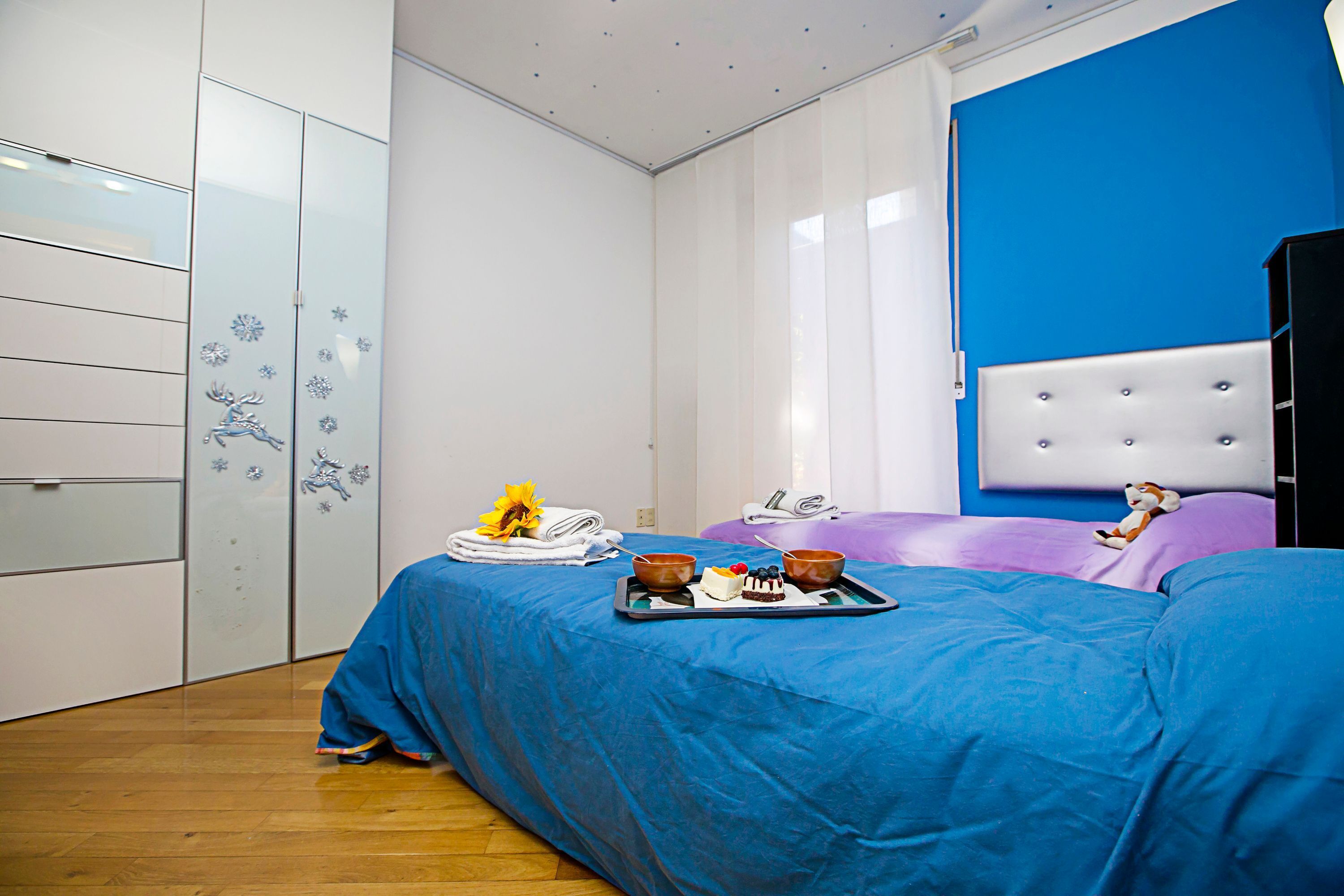 Ein Hotelzimmer mit Bett, Kleiderschrank und Fenster mit Jalousien.