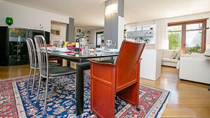 Ett modernt vardagsrum med en matplats, med en stor matta, ett matbord med stolar och en soffa.