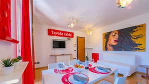 A modern dining area with a white table set for two, a red curtain, and a painting on the wall. - Claz House in Riva del Garda (Riva del Garda)