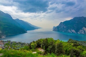 A coastal town with a view of a calm sea and mountains. - Claz House in Riva del Garda (Riva del Garda)
