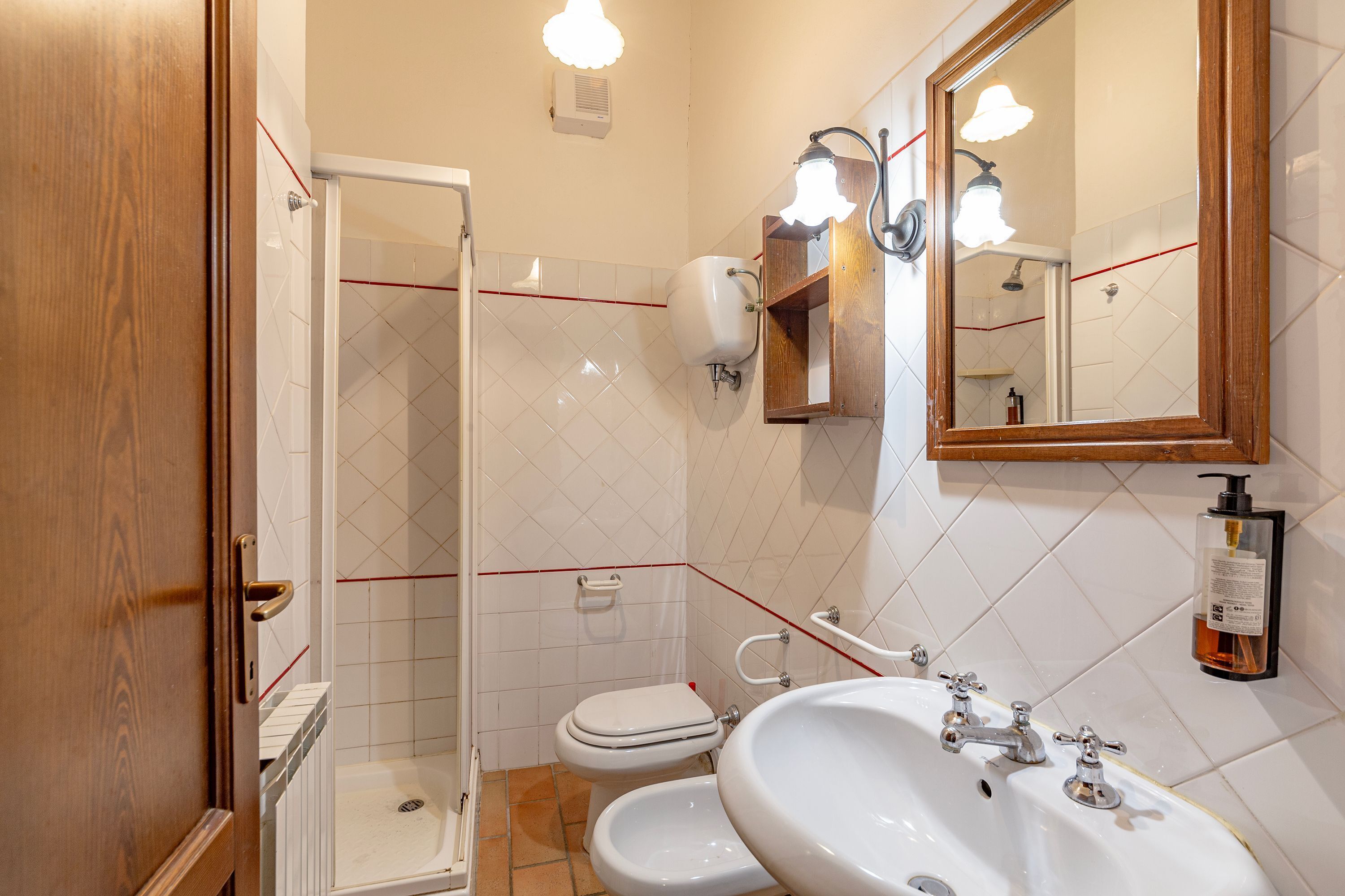 A bathroom with a shower, toilet, and sink.