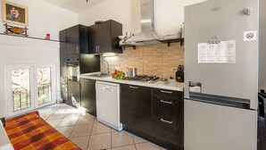 A modern kitchen with a dishwasher, stove, and refrigerator. - La Vie Enchanting Sea View (Alassio)