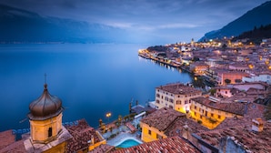 A coastal town with historic buildings, a bell tower, and a calm lake. - Il Piccolo Nido in Riva del Garda (Riva del Garda)