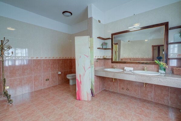 A modern bathroom with two sinks, a large mirror, and a toilet. - Villa Oasi With Private Pool (Sirmione)