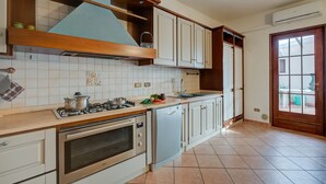 A kitchen with white cabinets, a gas stove, an oven, and a dishwasher. - Villa Oasi With Private Pool (Sirmione)
