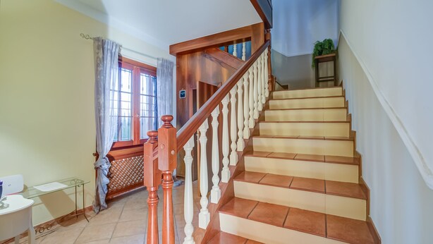 A staircase with wooden balusters and beige steps leading to a landing. - Villa Oasi With Private Pool (Sirmione)