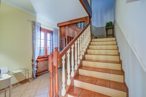 A staircase with wooden balusters and beige steps leading to a landing. - Villa Oasi With Private Pool (Sirmione)
