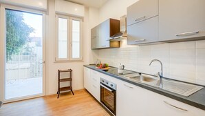 Una cocina moderna con un amplio ventanal, horno integrado y pileta de acero inoxidable.