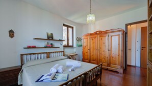 Een slaapkamer met een bed, een houten garderobe en een raam.