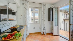 A kitchen with a window, a balcony, and a view of a building. - Riccardo House Stresa (Stresa)