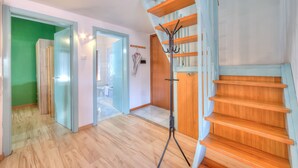 Een modern interieur met een houten trap, een statief en een groene wand.