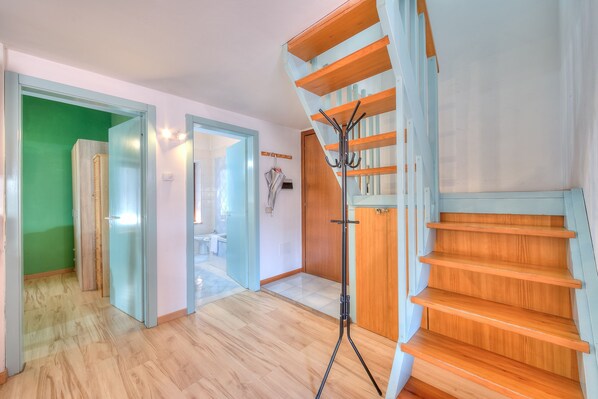 A modern interior with a wooden staircase, a tripod, and a green wall. - Loft Caneva in Riva del Garda (Riva del Garda)
