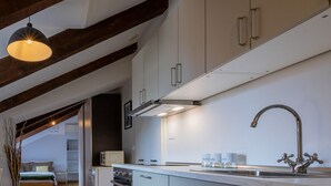 A modern kitchen with white cabinets, a stainless steel sink, and a wooden ceiling. - Barbaroux 10 - Luna by Wonderful Italy (Turin)
