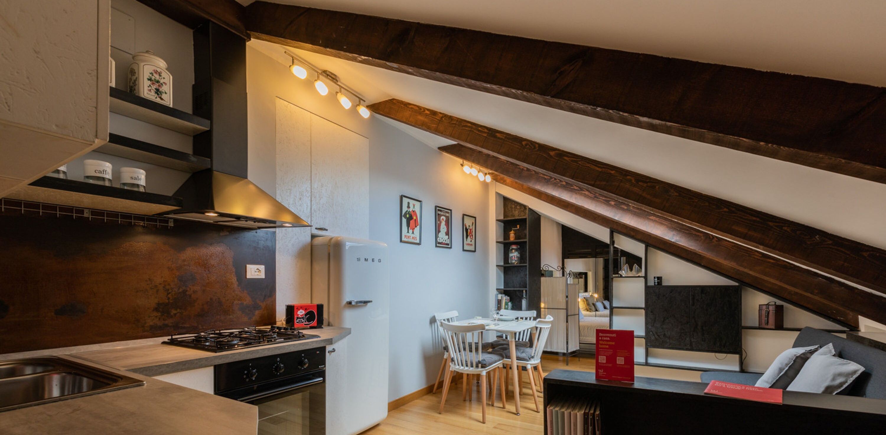 A kitchen with a stove, sink, and white cabinets. There is a dining area with a table and chairs.