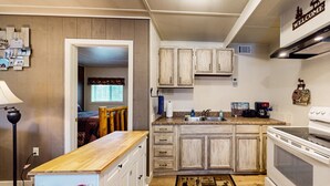 A kitchen with wooden cabinets, a stove, and a countertop. - Moose Hollow Apartment (Greenville)