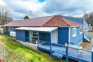 A blue house with a red roof, a porch with a table and chairs, and a small deck. - ATV ACCESS/WALK TO TOWN (Greenville)