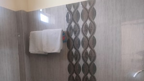 A bathroom with a toilet, sink, and a towel rack. - The Shagun Grand (Rohtak)