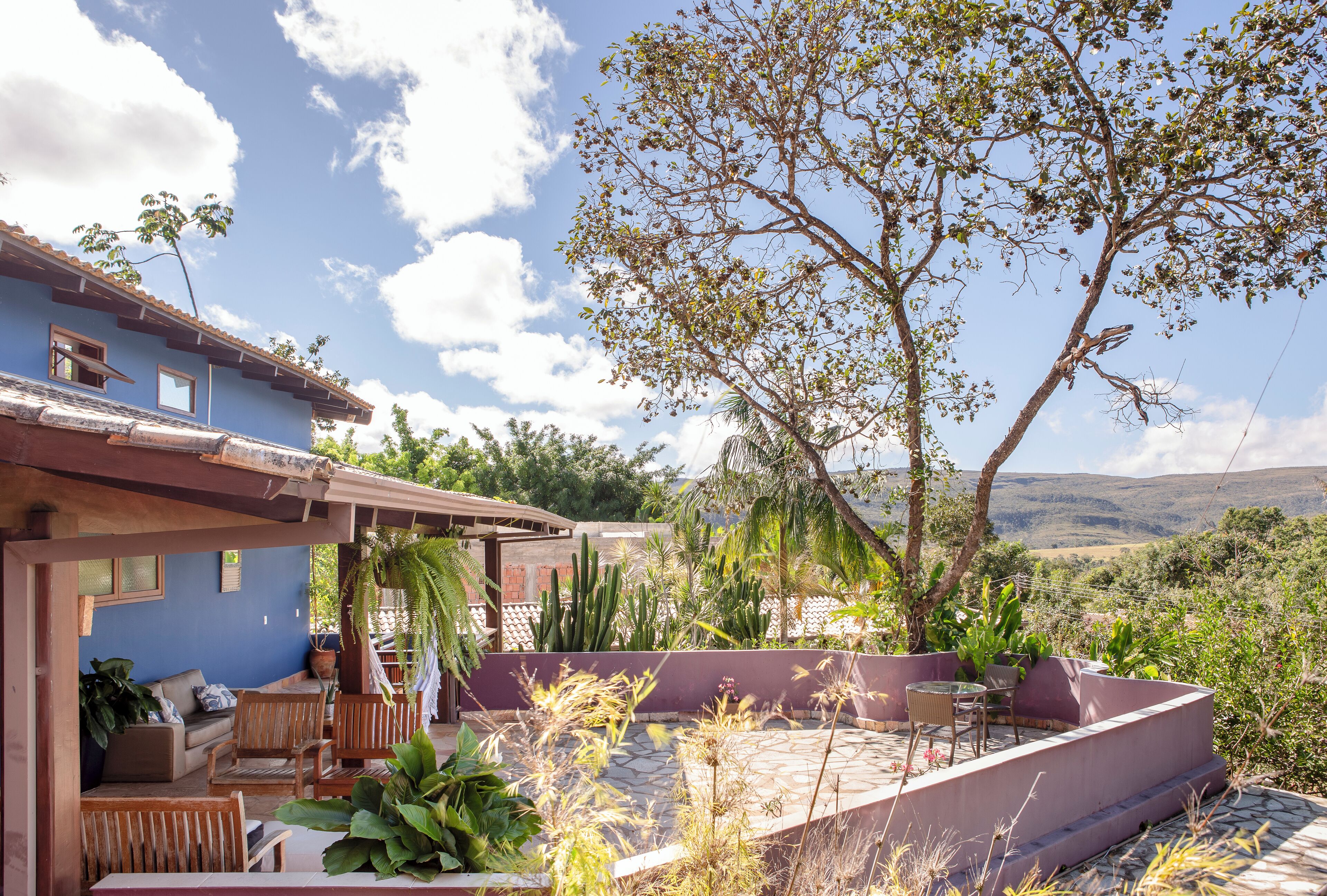 A patio area with outdoor furniture, a cactus garden, and a view of the countryside.