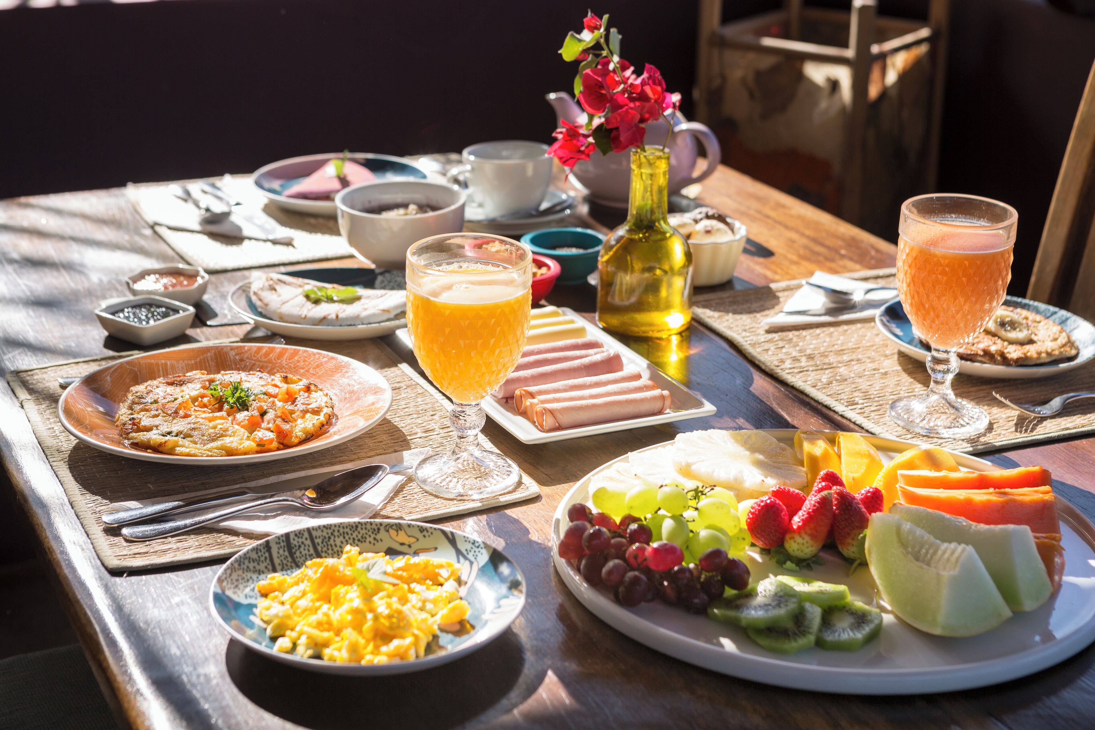 Ein Frühstückstisch mit verschiedenen Speisen, darunter Obst, Eier und Gebäck.