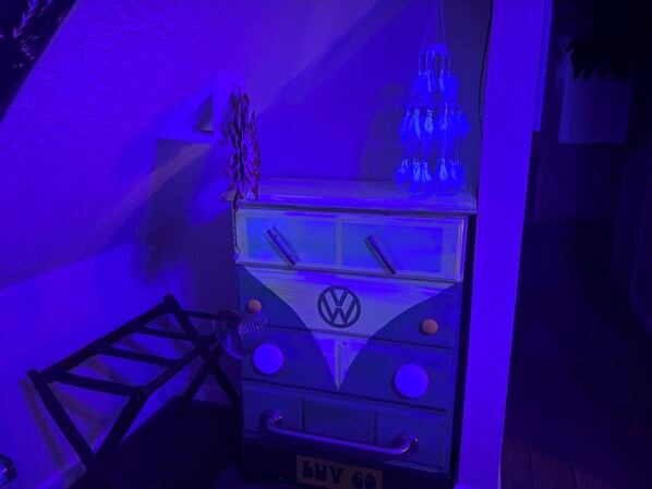 Una furgoneta camper Volkswagen con el logotipo de VW, una lámpara colgante pequeña y una escalera.