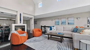 Un salon moderne avec un canapé, des fauteuils, une table basse et une cheminée.