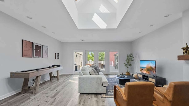 Una sala de estar moderna con mesa de billar, sofá y televisor.