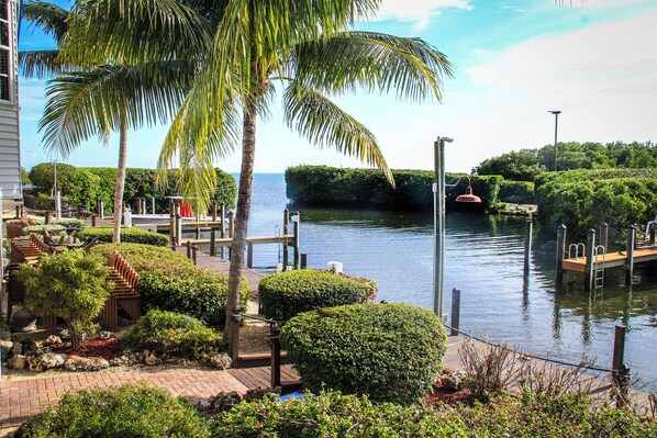 A waterfront property with a dock, palm trees, and a well-maintained garden.